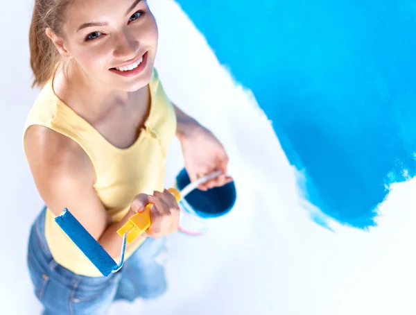 Happy beautiful young woman doing wall painting, standing on ladder — Stock Photo, Image