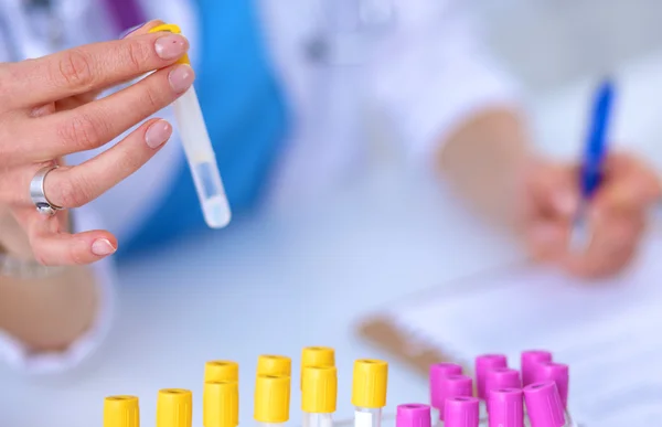 Woman researcher is surrounded by medical vials and flasks, isolated on white background — Stock Photo, Image