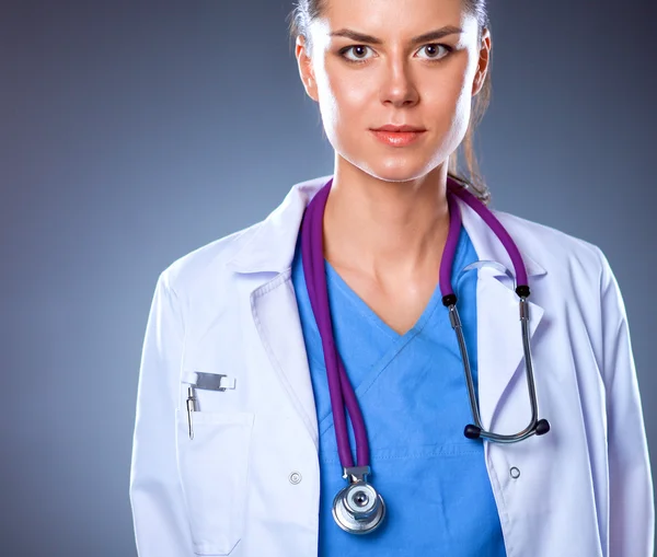 Молода лікарка зі стетоскопом ізольована на сірому — стокове фото