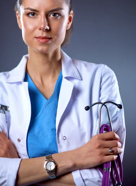 Retrato de una joven doctora sosteniendo un estetoscopio, aislada sobre fondo negro — Foto de Stock