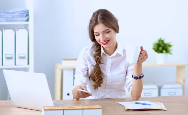 Atrakcyjna bizneswoman siedzi na biurku w biurze — Zdjęcie stockowe