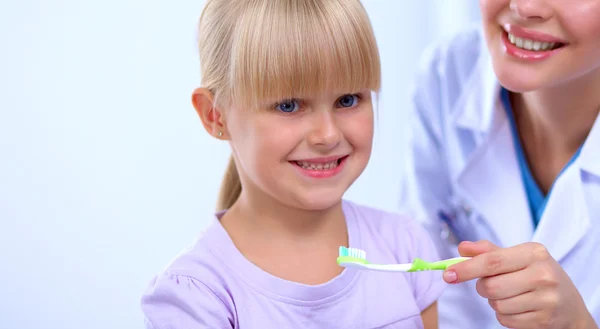 Tandläkare och liten flicka på tandläkarmottagningen. — Stockfoto