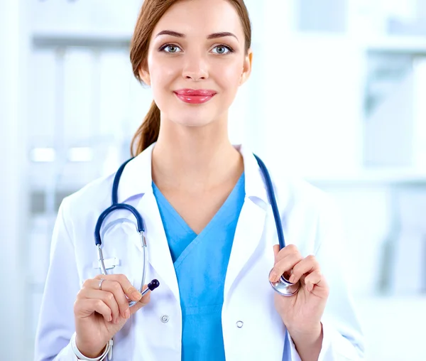 Portrait of young woman doctor with white coat standing in hospital — Stock Photo, Image