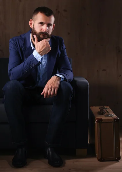 Geschäftsmann auf dem Sofa in der Büro-Lobby, isoliert auf dunklem Hintergrund — Stockfoto