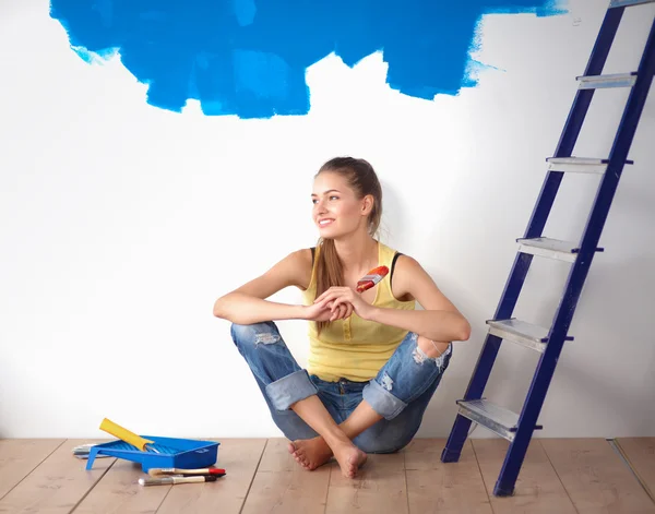 Retrato de pintora sentada en el suelo cerca de la pared después de pintar — Foto de Stock