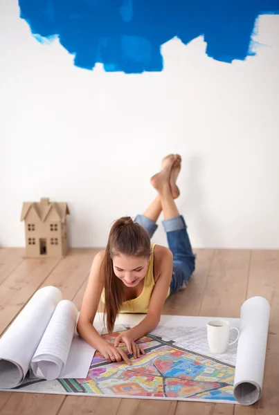 Porträtt av kvinnliga målare sitter på golvet nära väggen efter målning — Stockfoto