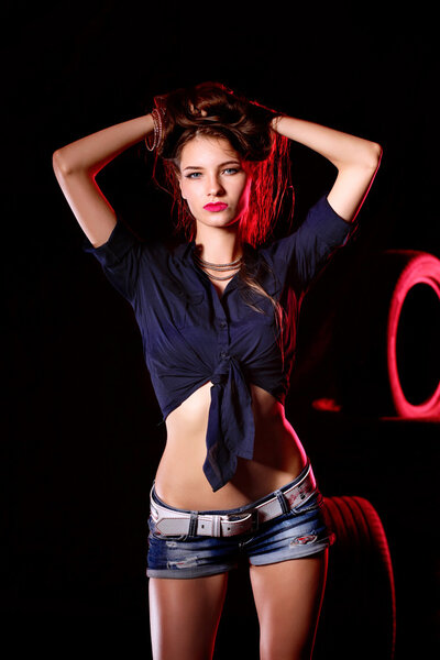 Portrait of young woman standing in the old garage. isolated on black background