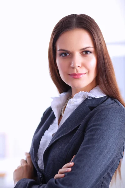 オフィスで腕を組んで立っているビジネス女性の肖像画 — ストック写真