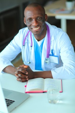 Masada dizüstü bilgisayarda çalışan genç bir Afrikalı doktor.