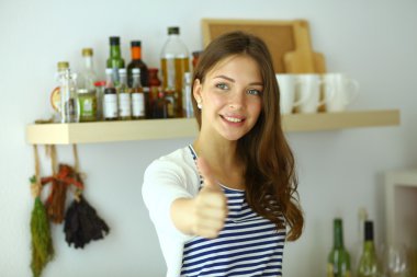 Mutfak masasında yakın duran ve ok gösterilen genç kadın