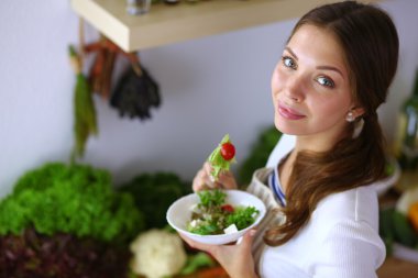 Salata yemek ve karışık salata tutan genç kadın