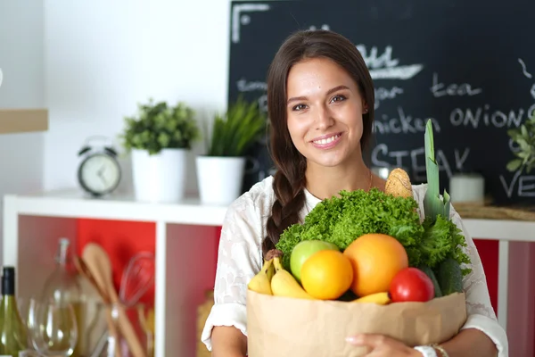 Mujer joven sosteniendo bolsa de la compra de comestibles con verduras —  Fotos de Stock