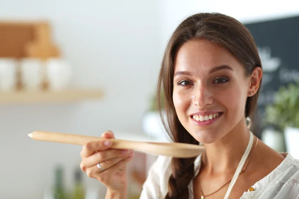 Mujer cocinera en cocina con cuchara de madera —  Fotos de Stock