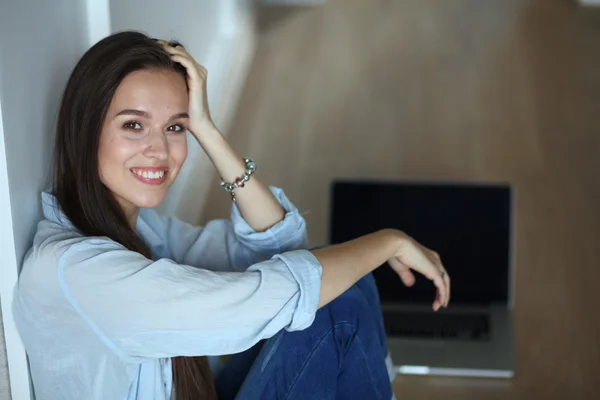 Junge schöne Frau zu Hause sitzt auf dem Boden mit Laptop — Stockfoto