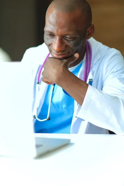 Masada dizüstü bilgisayarda çalışan genç bir Afrikalı doktor. — Stok fotoğraf