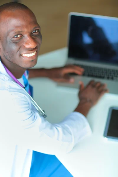 Masada dizüstü bilgisayarda çalışan genç bir Afrikalı doktor. — Stok fotoğraf