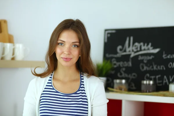 Jeune femme debout près du bureau dans la cuisine — Photo