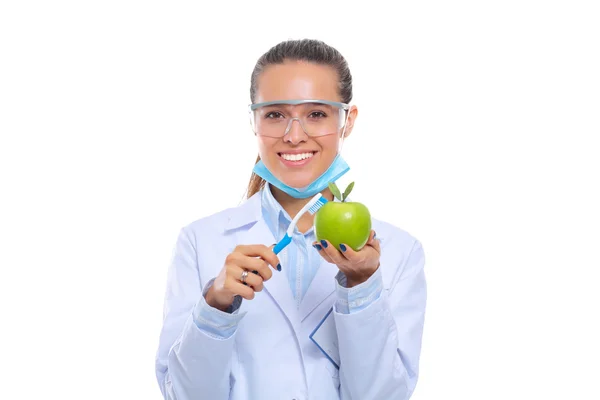 牙科医生女医生手里拿着绿色新鲜苹果和牙刷 — 图库照片