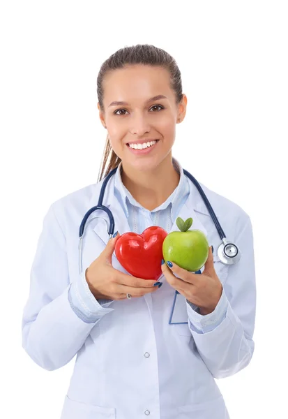Bella sorridente medico femminile con cuore rosso e mela verde — Foto Stock