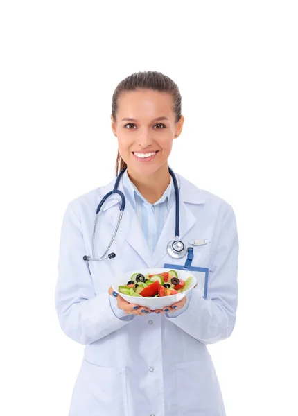 Retrato de una hermosa doctora sosteniendo un plato con verduras frescas . — Foto de Stock