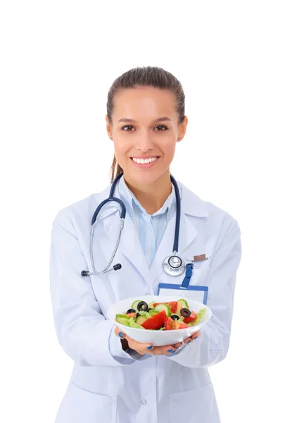 Portrait of a beautiful woman doctor holding a plate with fresh vegetables. — Stock Photo, Image