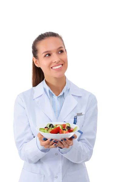 Retrato de una hermosa doctora sosteniendo un plato con verduras frescas . — Foto de Stock