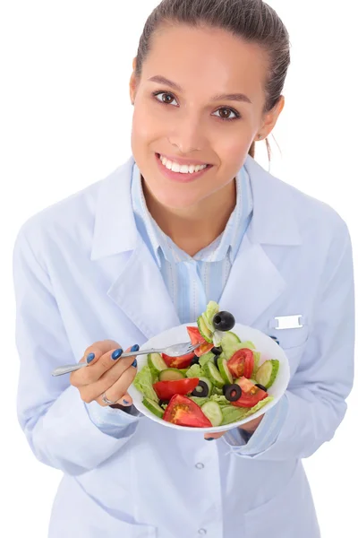 Porträtt av en vacker kvinna läkare som håller en tallrik med färska grönsaker. — Stockfoto