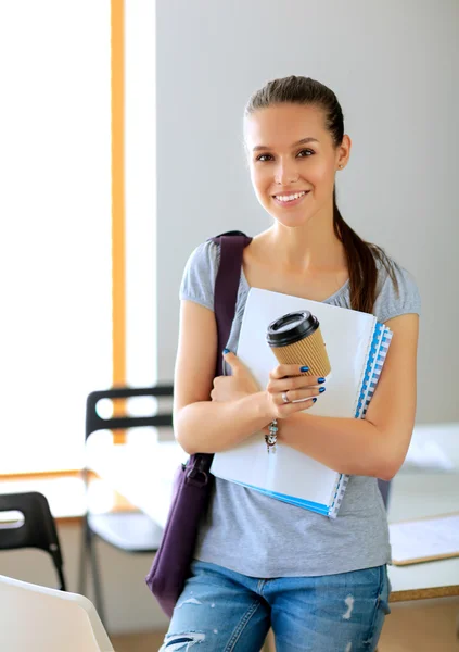 Smiling student with folders and cup of coffee — Stock Photo, Image