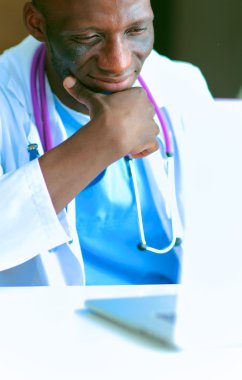 Masada dizüstü bilgisayarda çalışan genç bir Afrikalı doktor.