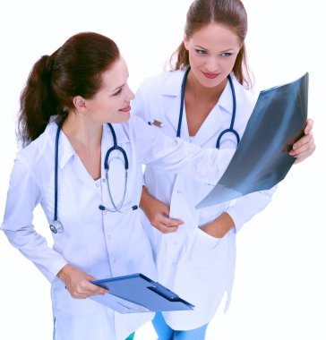 Röntgen filmini izleyen iki kadın hemşire, hastanede duruyor.