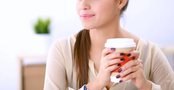 Ung affärskvinna sitter på skrivbordet med kopp — Stockfoto