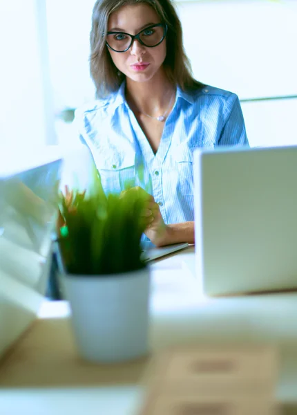 Jovem mulher sentada à mesa do escritório com laptop — Fotografia de Stock