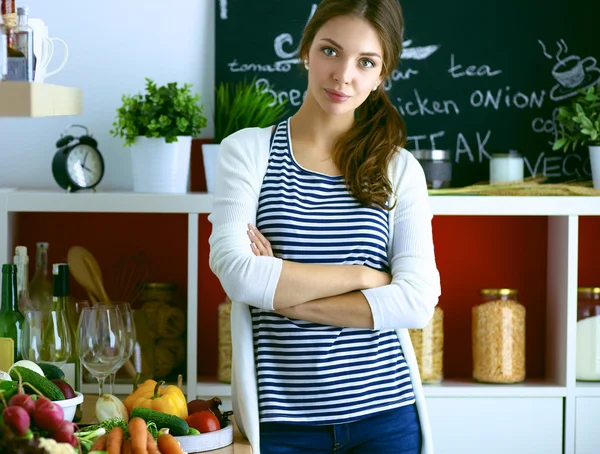 Wanita muda berdiri dekat meja di dapur — Stok Foto