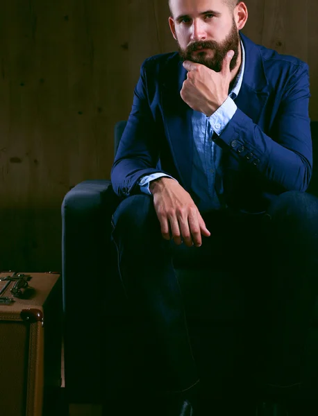 Empresário sentado no sofá no lobby do escritório, isolado no fundo escuro — Fotografia de Stock
