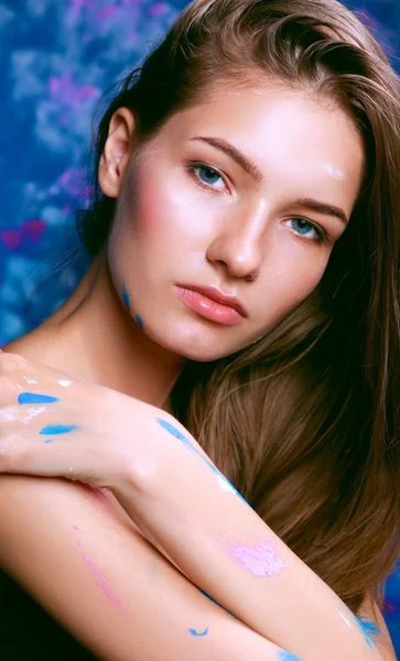 Young woman sitting near painting wall — Stock Photo, Image