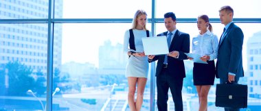 Toplantı sırasında dizüstü bilgisayarla sunum yapan bir grup iş adamı