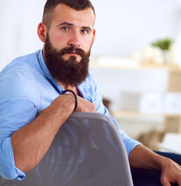 Jungunternehmer sitzt auf Stuhl im Büro — Stockfoto