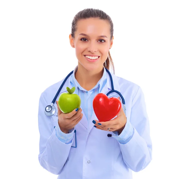 Hermosa doctora sonriente sosteniendo corazón rojo y manzana verde —  Fotos de Stock