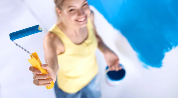 Feliz bela jovem fazendo pintura de parede, de pé na escada — Fotografia de Stock