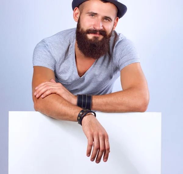 Retrato de un joven con sombrero de pie cerca del blanco, aislado sobre fondo blanco —  Fotos de Stock
