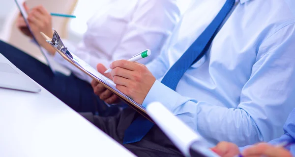 Zakenmensen zitten en schrijven op zakelijke bijeenkomst, in functie — Stockfoto