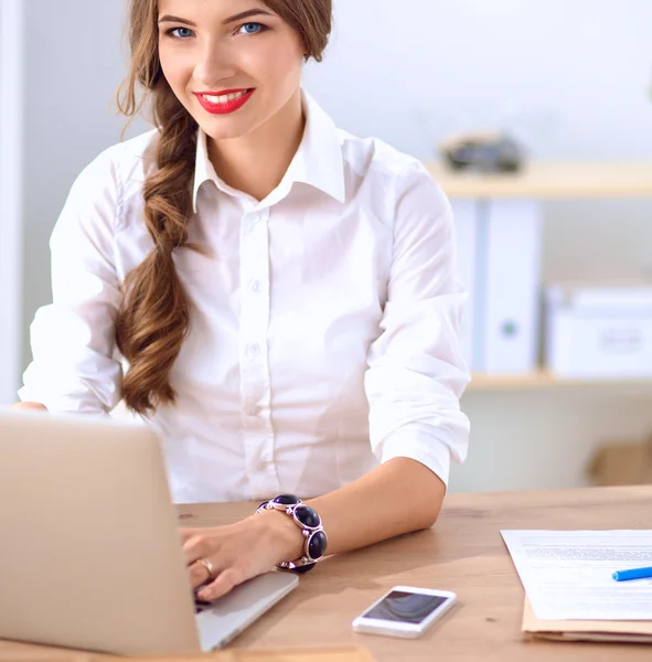 Empresária atraente sentada na mesa no escritório — Fotografia de Stock