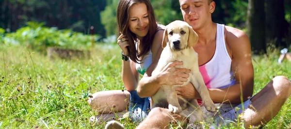 Una coppia sorridente con il cane all'aperto — Foto Stock