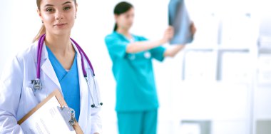 Kadın doktor hastanede dosyayla bekliyor.