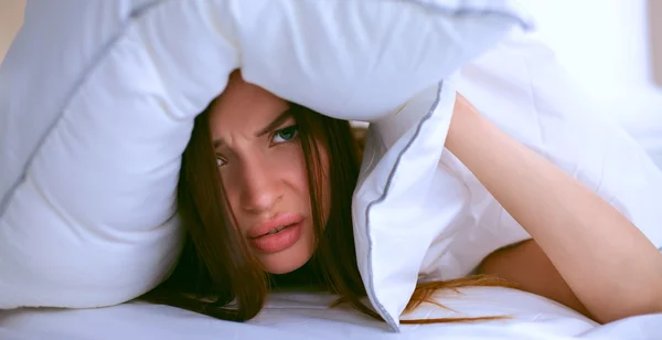 Vrouw liggend op bed en sluiten haar oren met kussen — Stockfoto