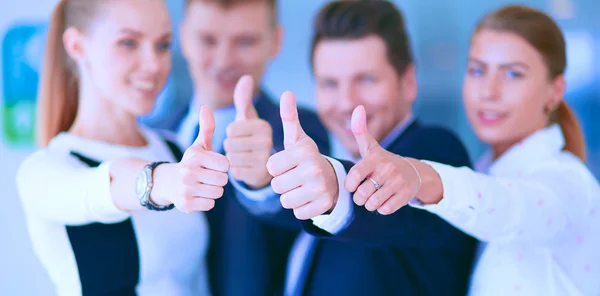 Happy business team showing thumbs up in office — Stock Photo, Image