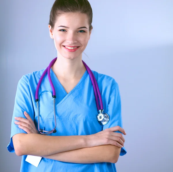 Médecin souriante avec un dossier en uniforme debout à l'hôpital — Photo