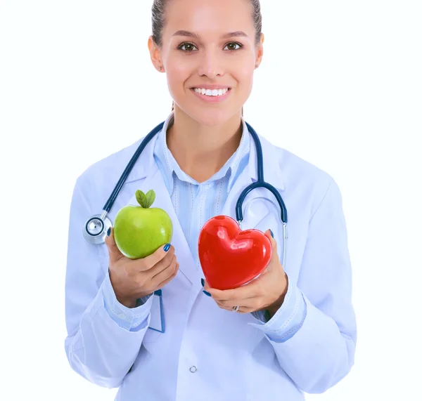 Krásná usmívající se doktorka drží červené srdce a zelené jablko — Stock fotografie