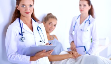 Hastanede üniformalı, gülümseyen bir kadın doktor.