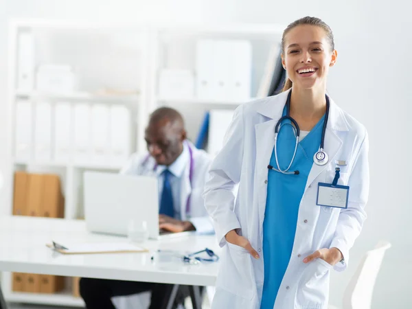 Una dottoressa sorridente con una cartella in uniforme all'interno — Foto Stock